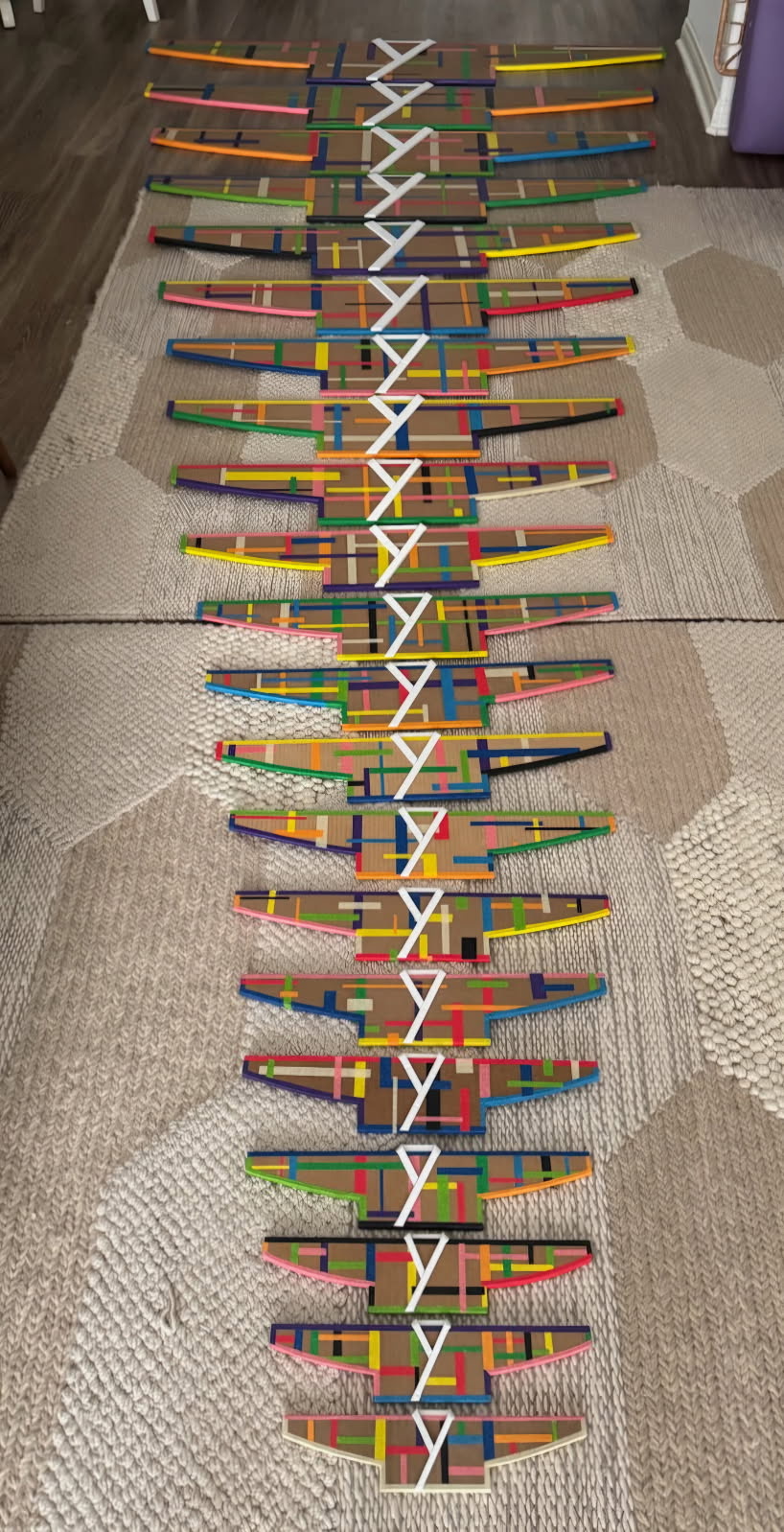 Colorful modular installation components by Hyungjoo Kim arranged in a long sequence.